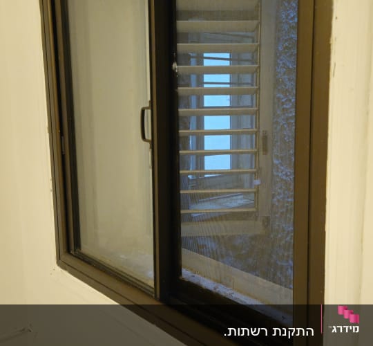 חלון עם תריסים פנימיים במבנה